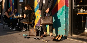 Stylish urban person showcasing 레플리카 fashion items against a vibrant mural.